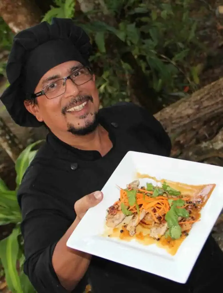 A man holding up a plate of food.
