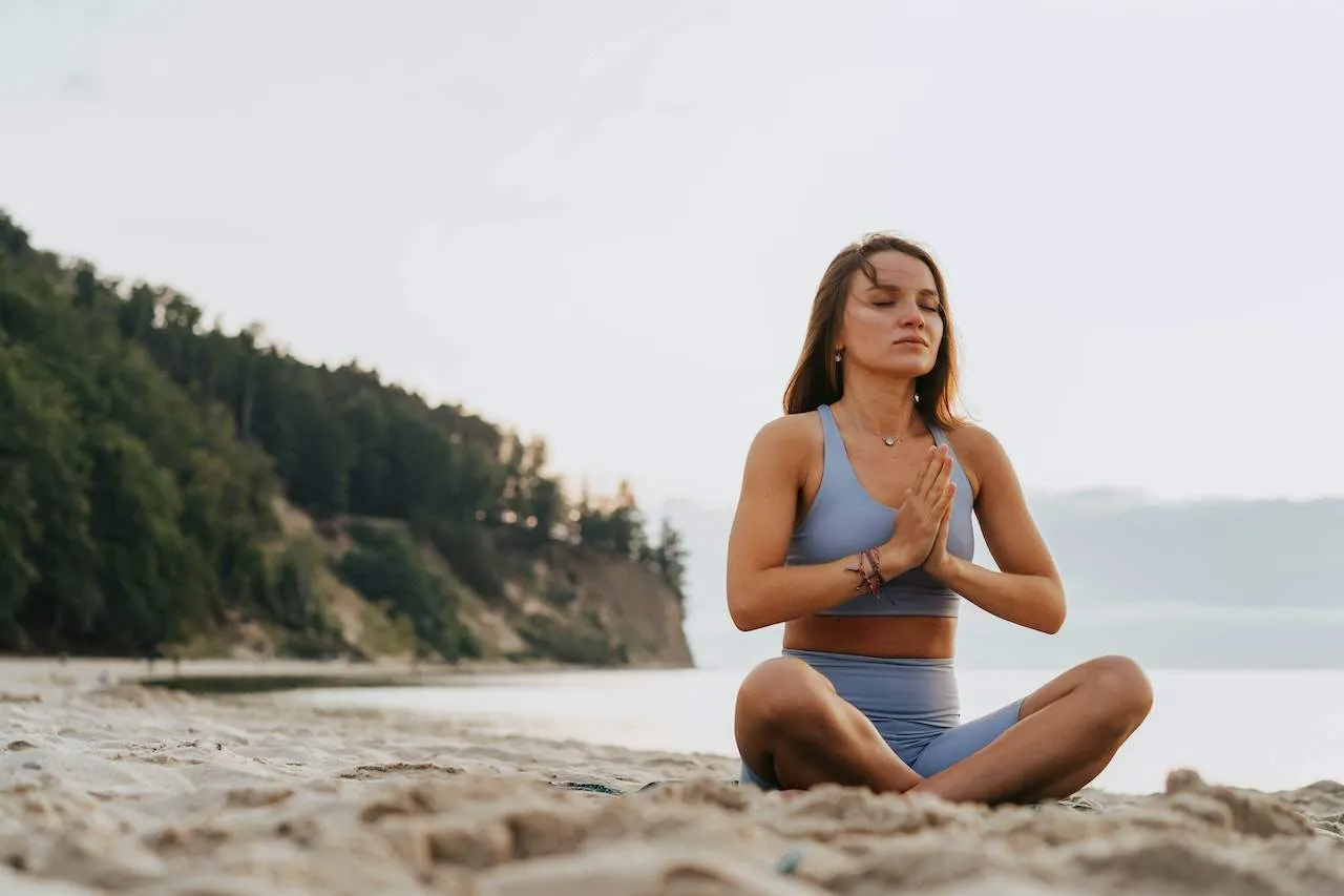 Young woman meditating on the beach.